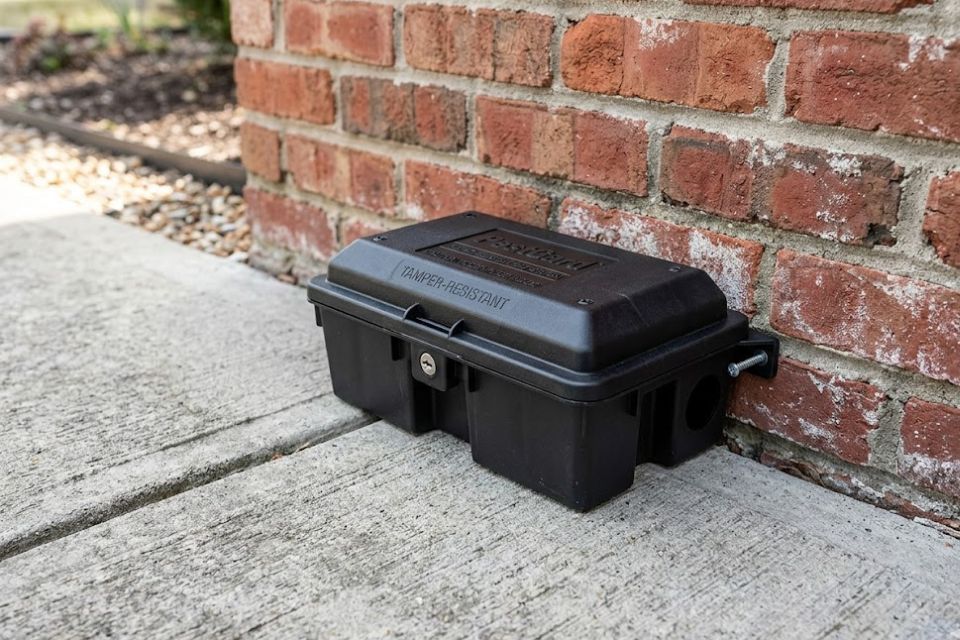 Tamper-resistant rodent bait station installation on a residential perimeter